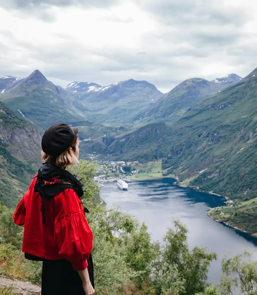 Norveç'teki manzaralı bir dağ seyir noktasından Geirangerfjord vadisine bakan bir gezgin