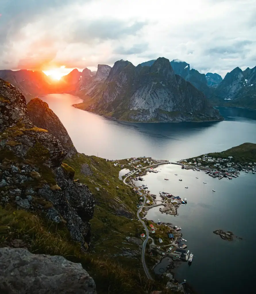 Fiyortlar ve sarp dağlarla çevrili Lofoten balıkçı köyünün gün batımı manzarası